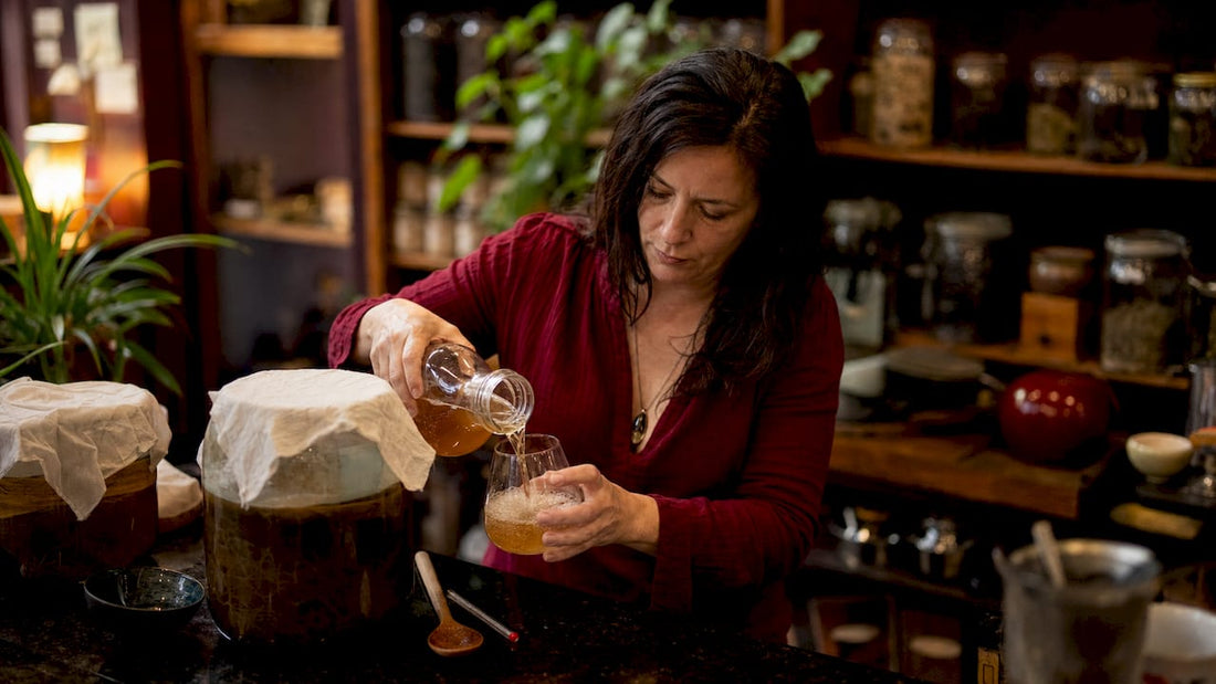 Woman placing kombucha jar on kitchen counter