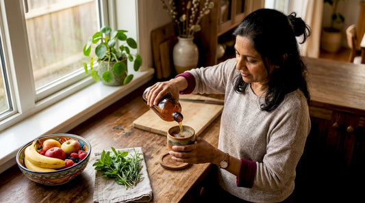 Woman pouring kombucha in kitchen