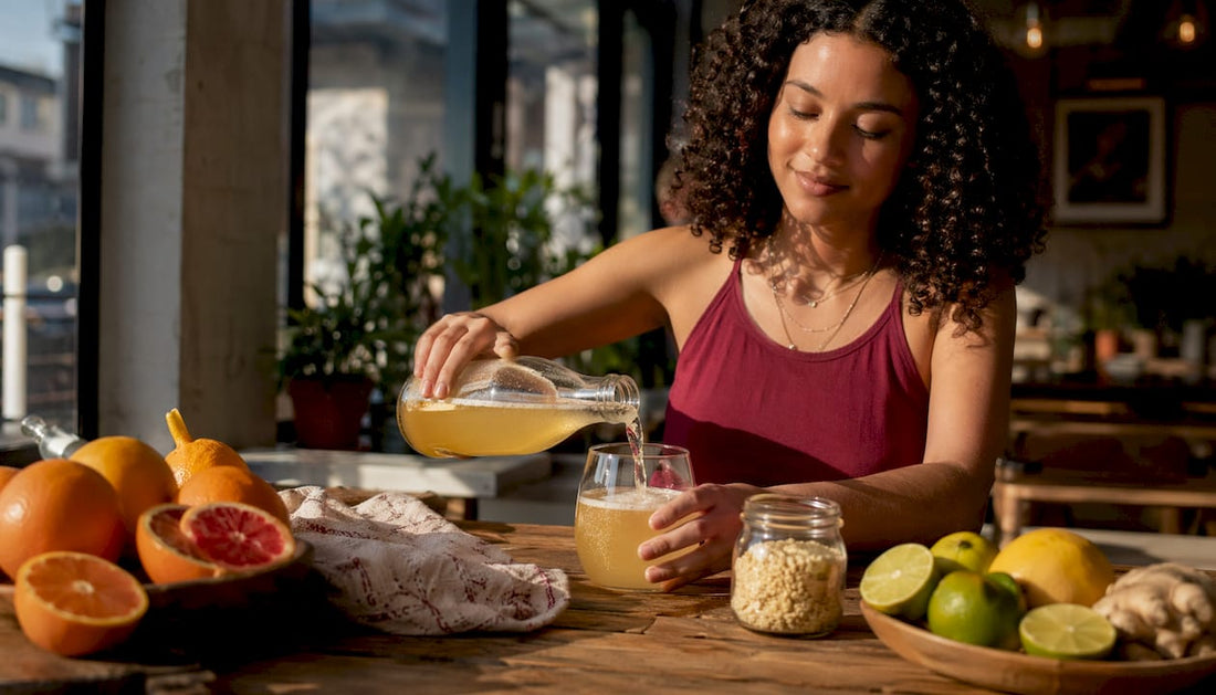 Woman pouring natural kombucha in kitchen