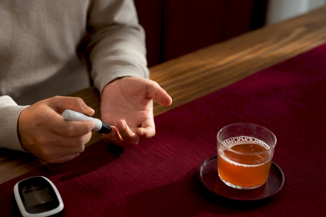 Blood glucose check beside kombucha glass