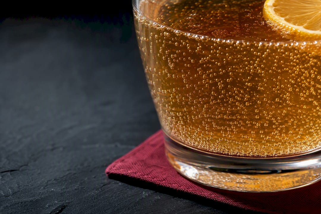 Bubbly kombucha beside a citrus wedge